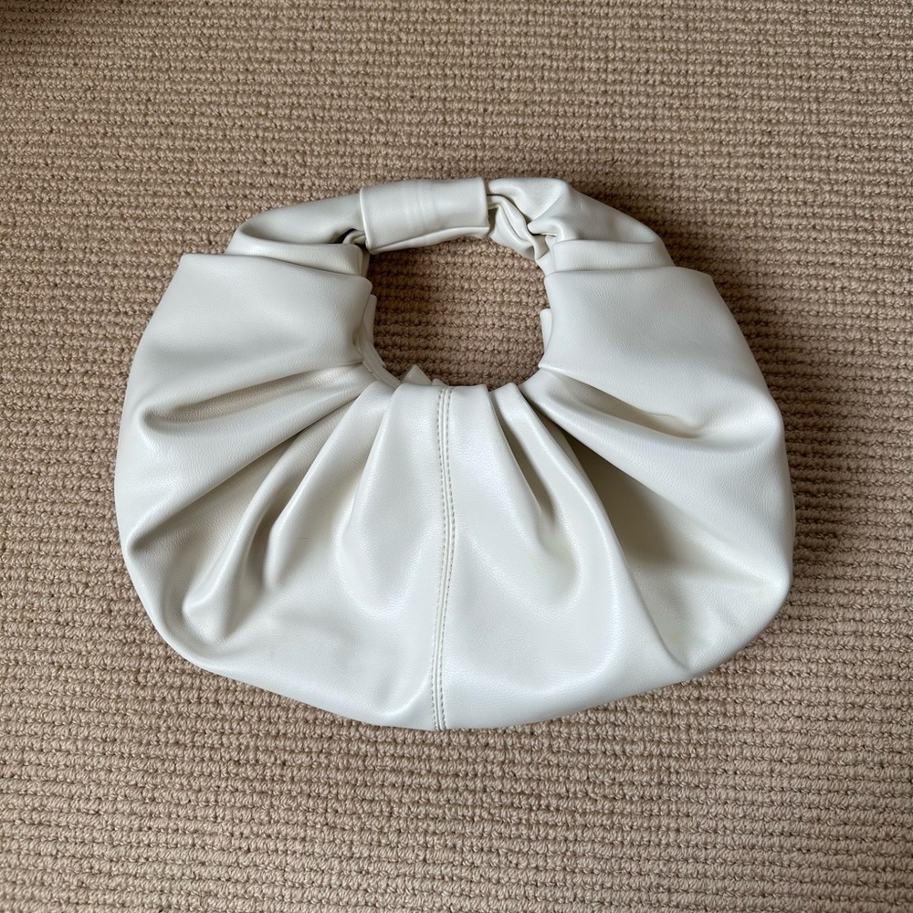 Cream gathered leather bag with top handle.